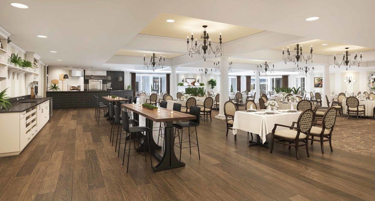 A spacious and elegantly decorated restaurant interior with wooden floors, featuring long tables, stylish chairs, and chandeliers.