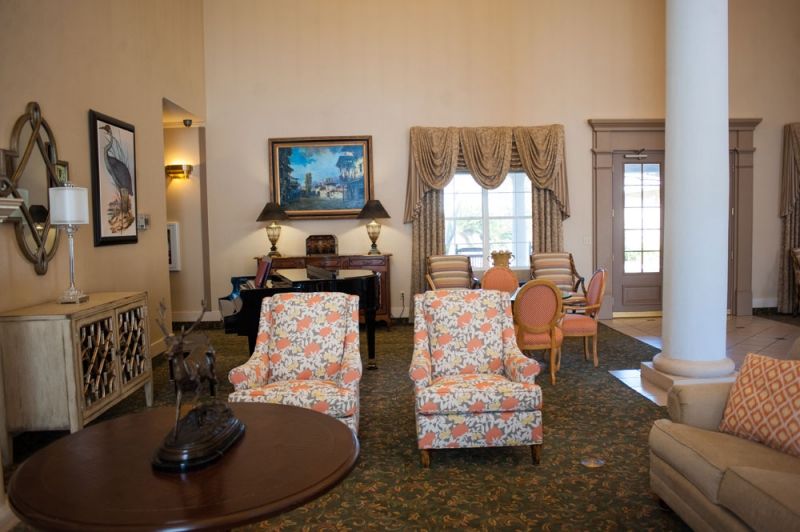 A cozy living room with floral-patterned chairs, a wooden table, and elegant decor.