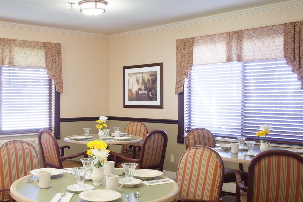 A cozy dining room with elegantly set tables and comfortable chairs.