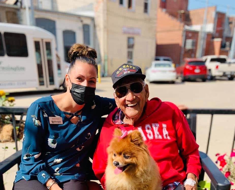 Two people and a dog enjoying a sunny day outside.