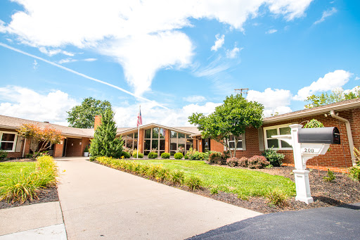 A beautiful residential building surrounded by greenery and a clear blue sky.