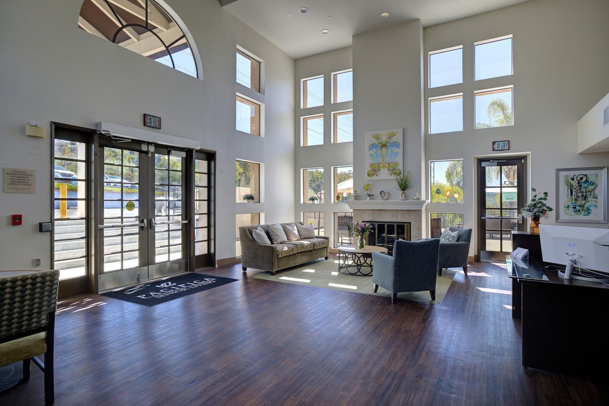 A spacious and well-lit lobby area with modern furniture and large windows.
