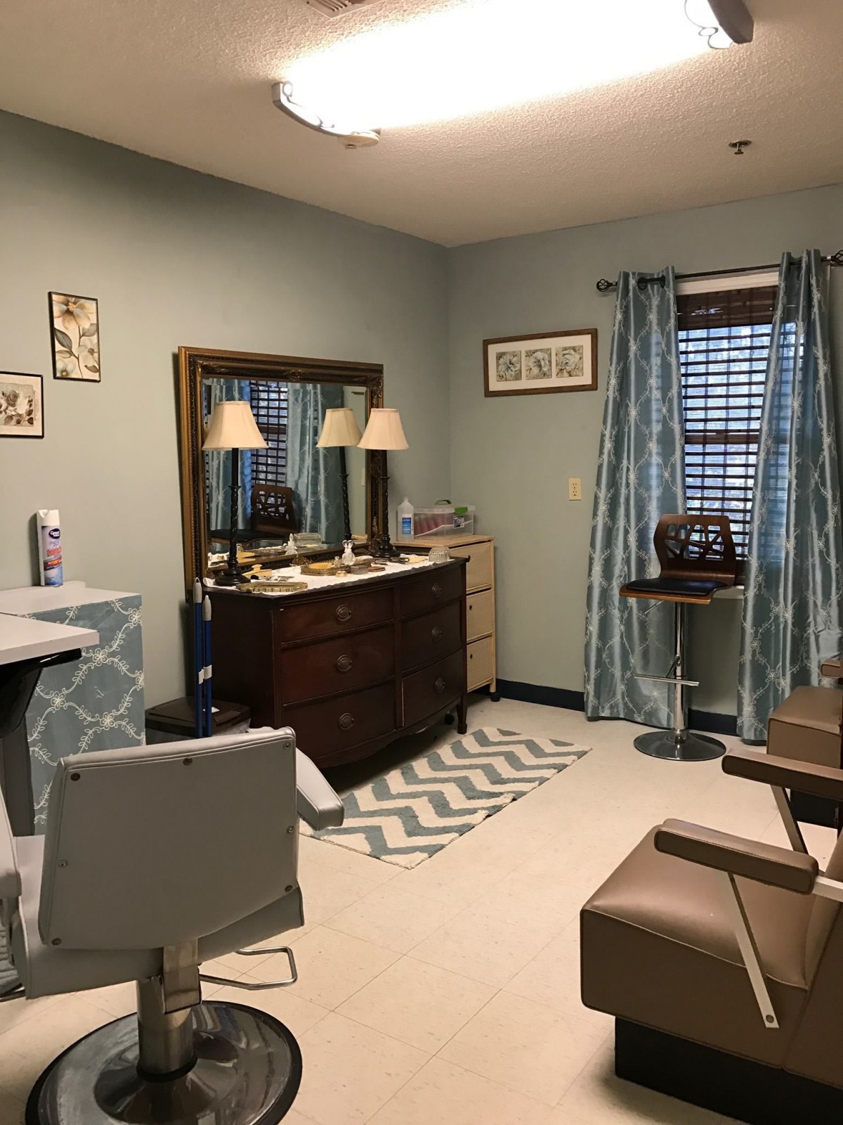 A cozy room with a dresser, mirror, and seating area.