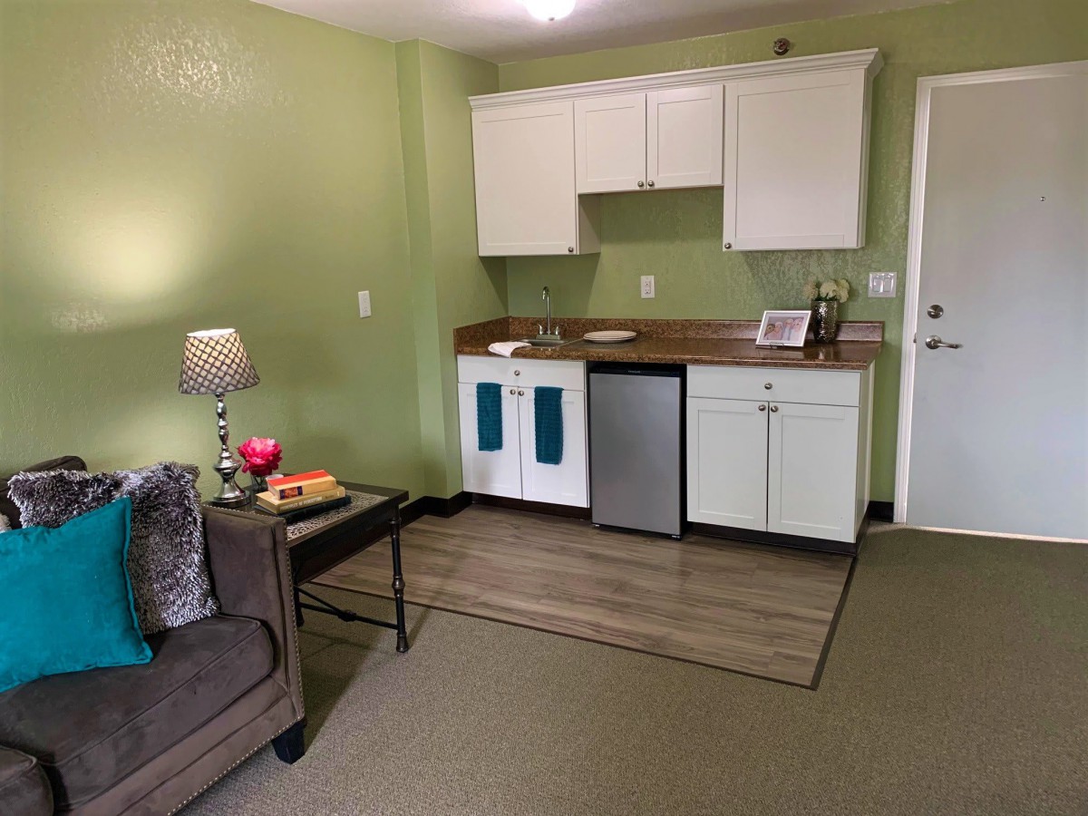 A cozy apartment with a small kitchenette and a comfortable living area.