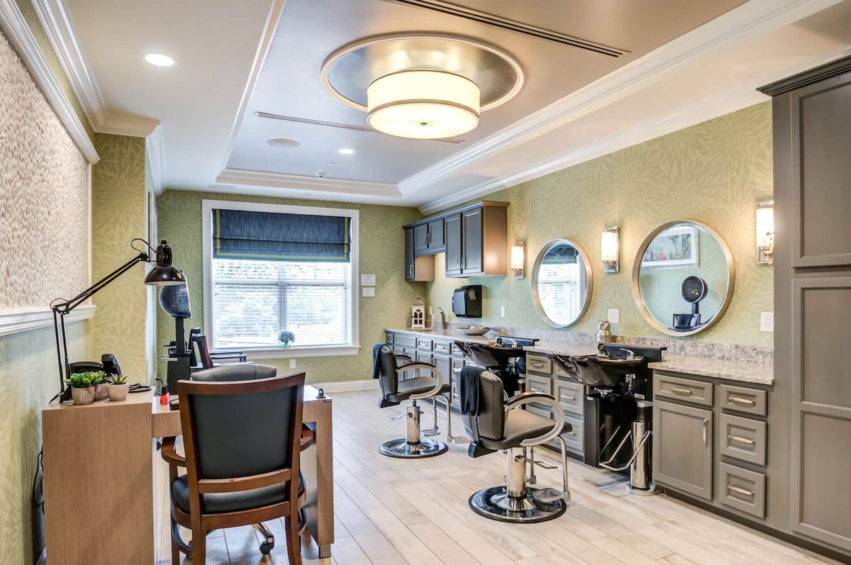 A modern hair salon interior featuring stylish decor with mirrors, barber chairs, and ambient lighting.