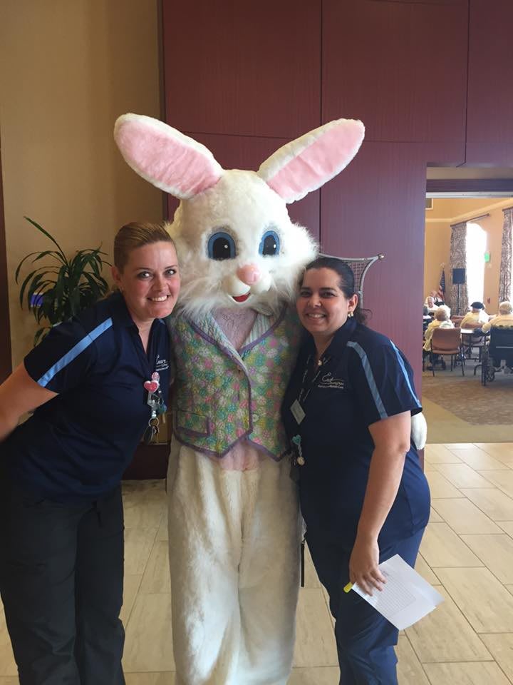 Two people posing with an Easter Bunny costume at an indoor event.