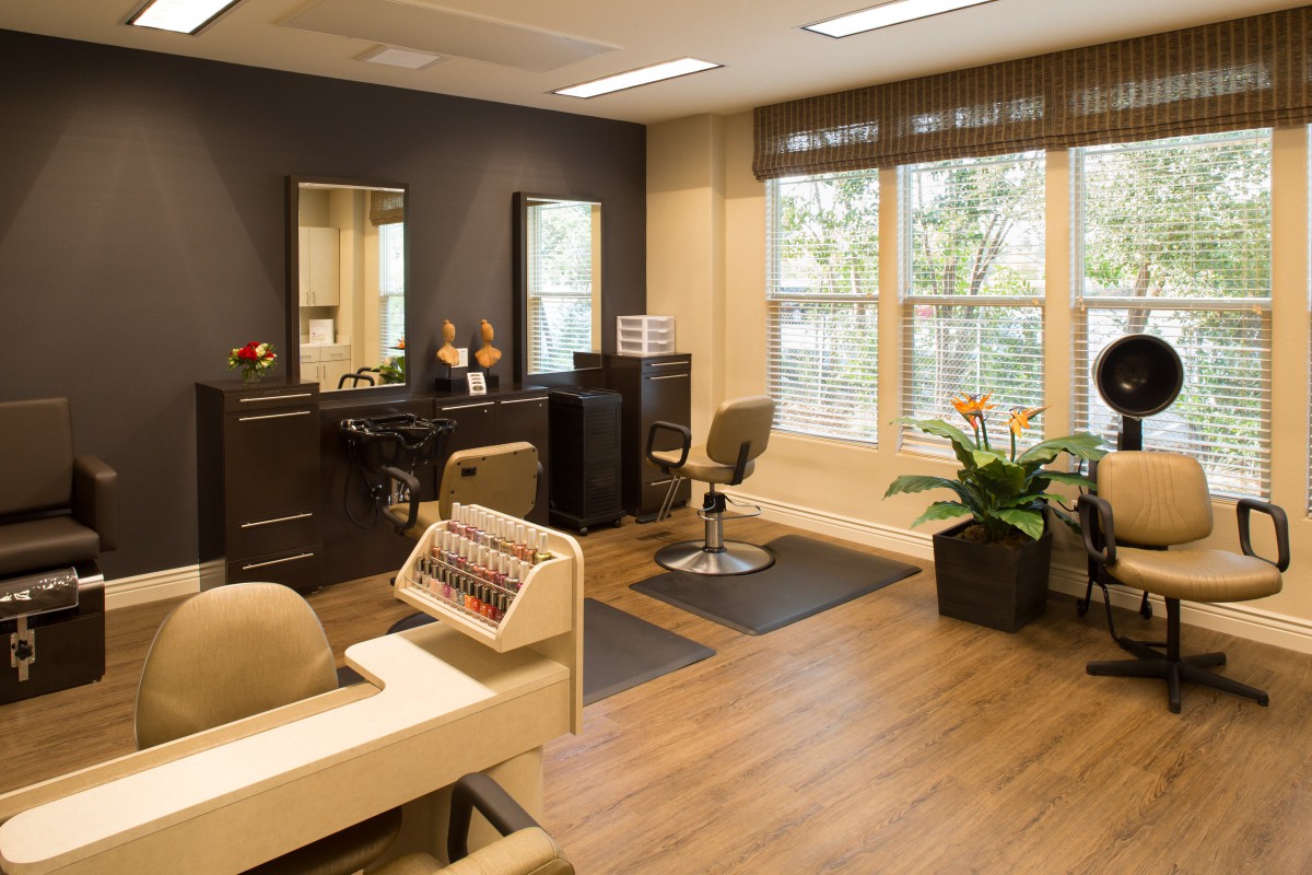 A modern beauty salon with stylish furnishings, mirrors, and indoor plants.