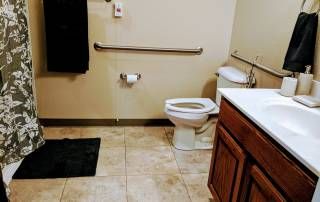 A clean bathroom with a toilet, sink, and black towel.