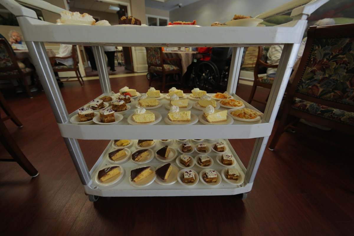 A cart filled with a variety of desserts in a restaurant setting.