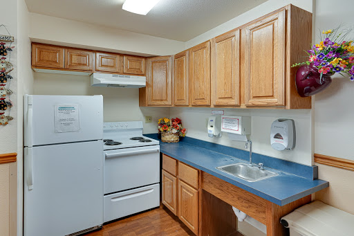 A cozy kitchen featuring wooden cabinets, a modern stove, and essential appliances.