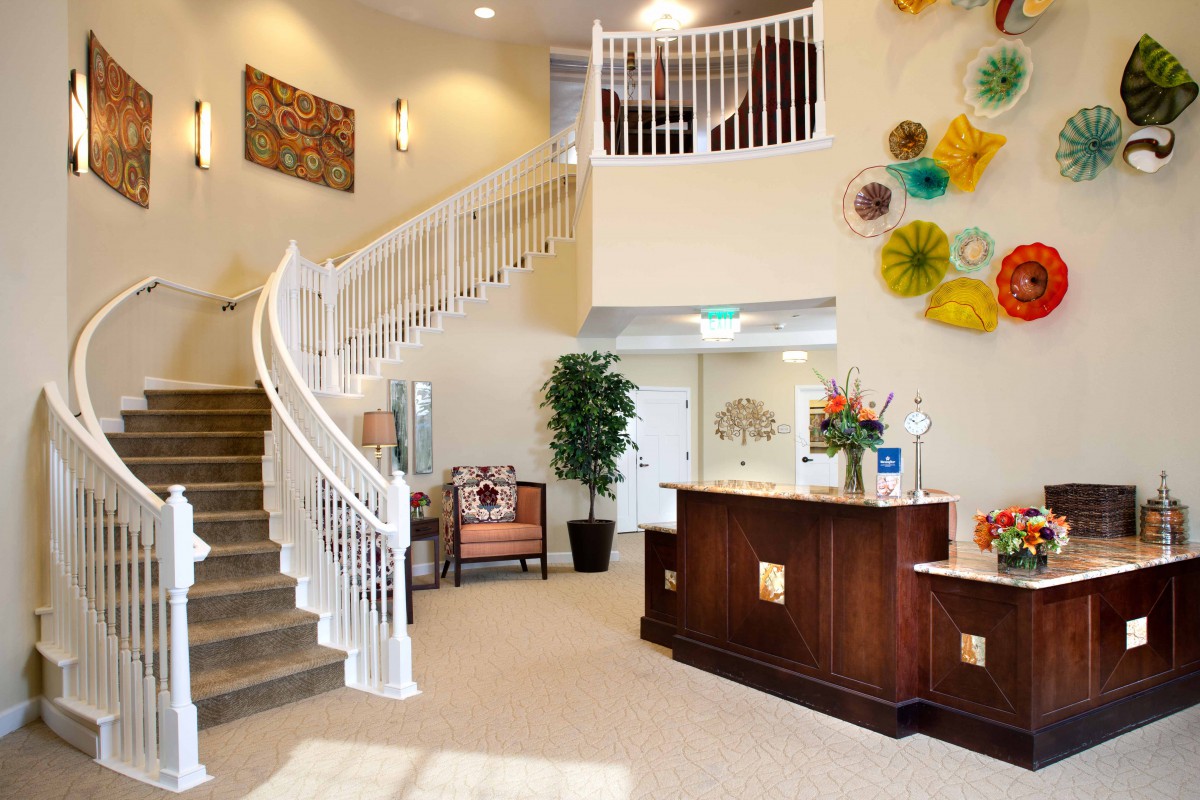 A modern lobby with a sweeping staircase and decorative elements.