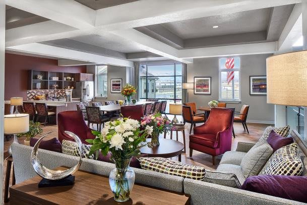 A luxurious and spacious living room with modern furniture and a floral arrangement centerpiece.