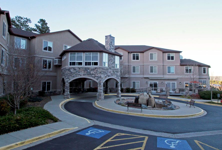 A large residential building with a stone facade and an accessible entrance.