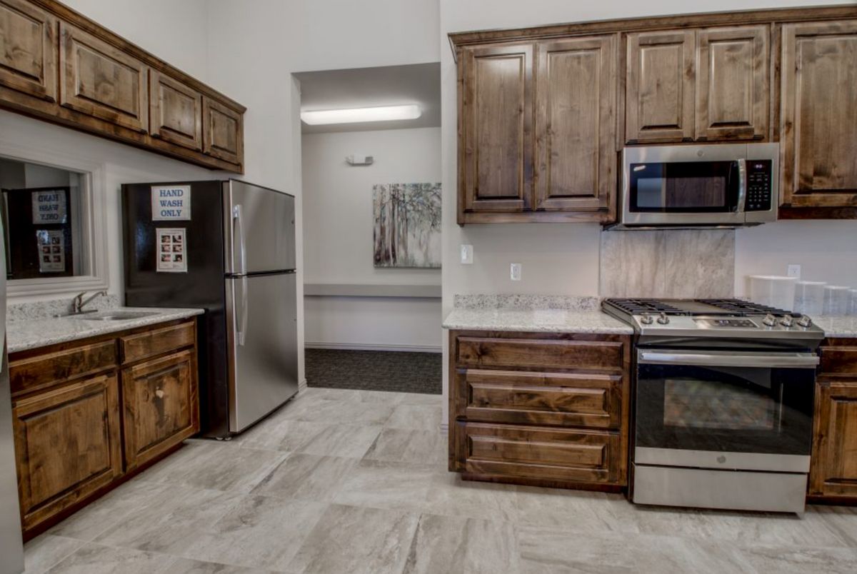 A modern kitchen featuring wooden cabinets and stainless steel appliances.