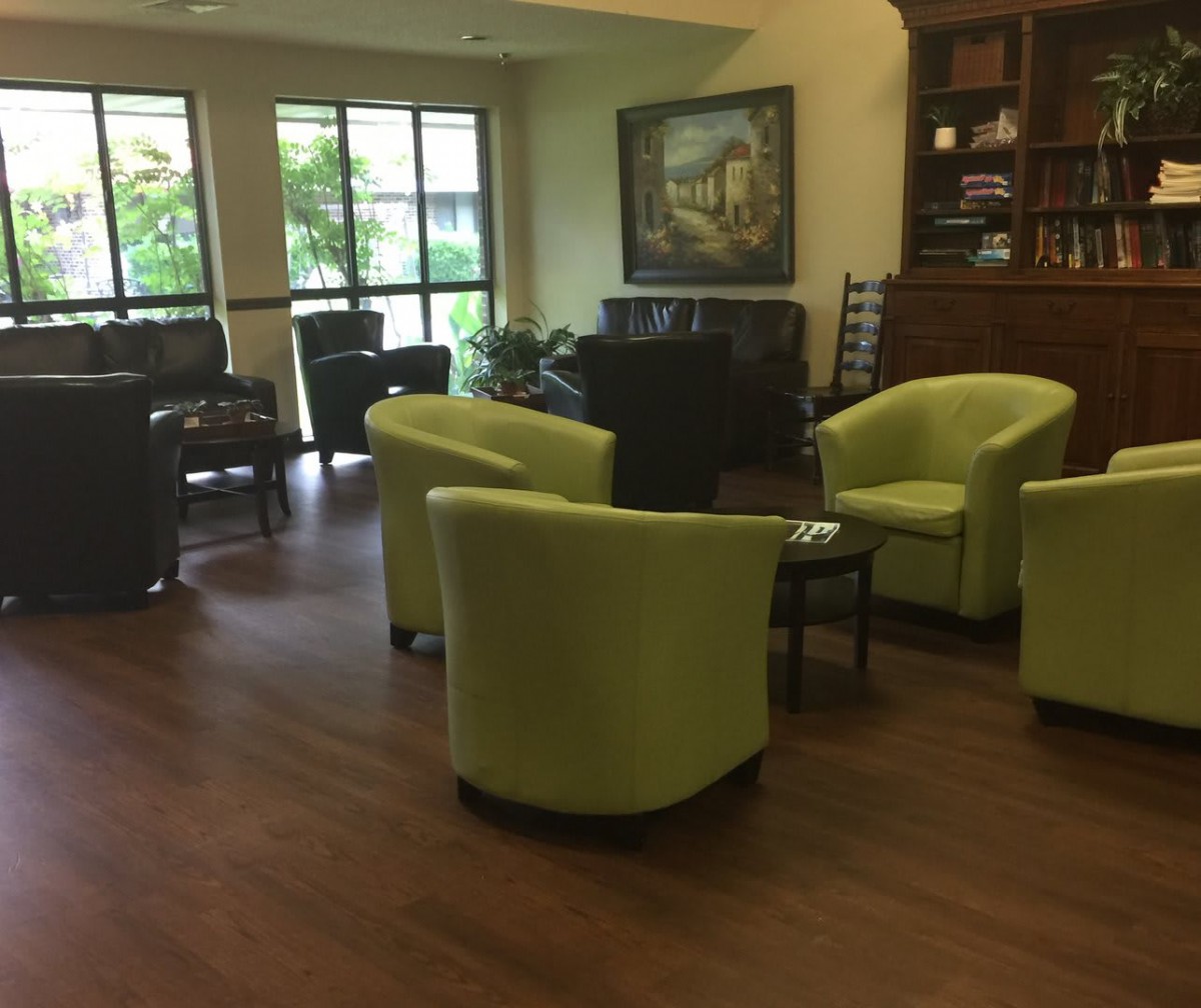 A cozy waiting area with green chairs and a warm ambiance.