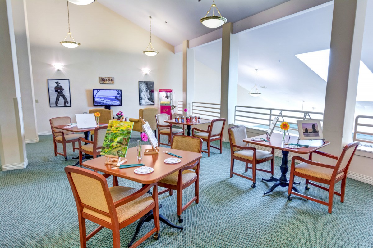 A cozy dining area with neatly arranged tables and chairs, adorned with decorative items and warm lighting.