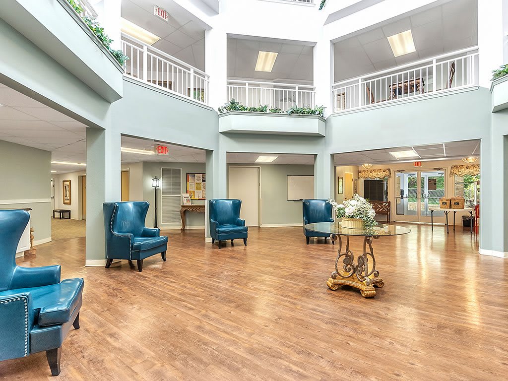 A spacious and bright lobby area with elegant furniture and wooden flooring.