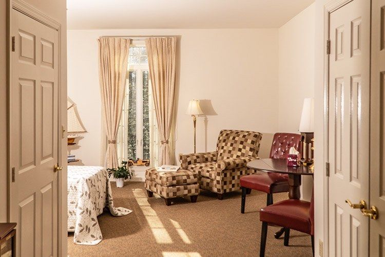 A cozy living room with patterned armchairs, a table, and soft lighting.