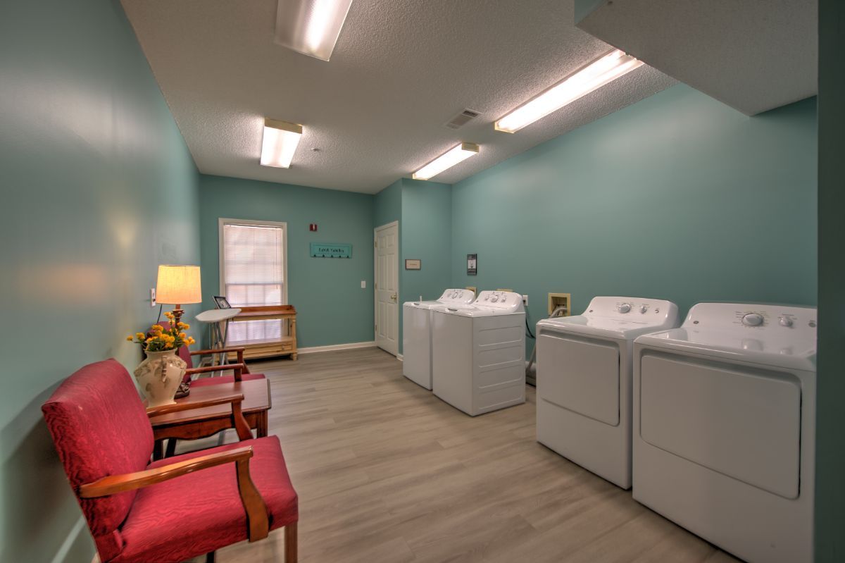 A tidy laundry room featuring washing machines, dryers, and comfortable seating.