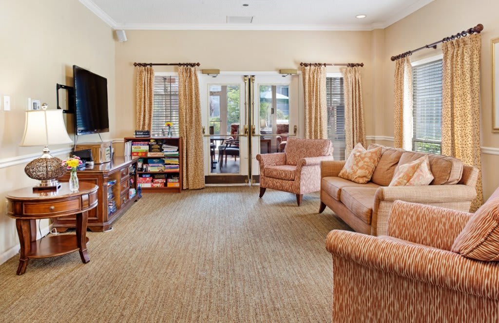 A cozy living room with comfortable seating, a television, and a bookshelf.