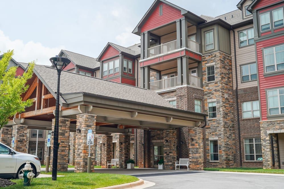 A multi-story residential building with a stone facade and covered entrance.