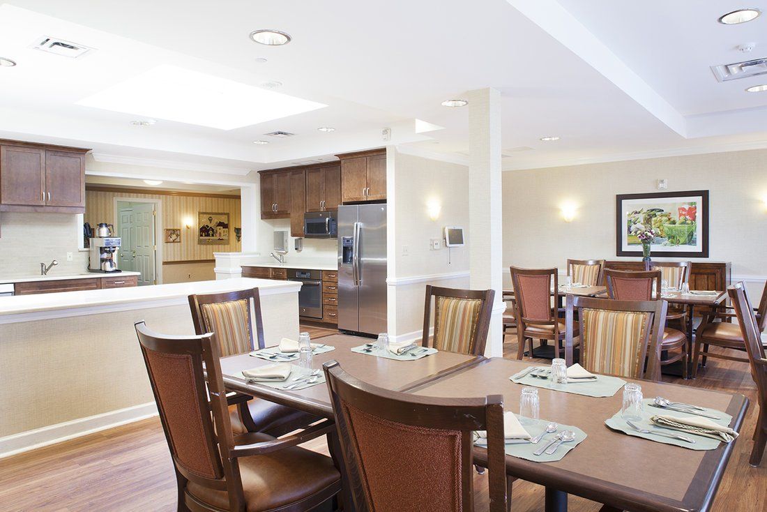 A modern dining area adjacent to a well-equipped kitchen, featuring wooden furniture and a warm, inviting atmosphere.