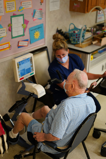 A nurse assists an elderly patient with medical monitoring in a healthcare setting.