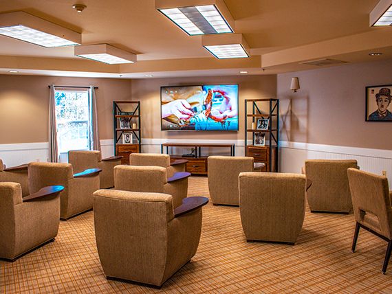 A cozy lounge area with comfortable chairs facing a large television, ideal for home entertainment.