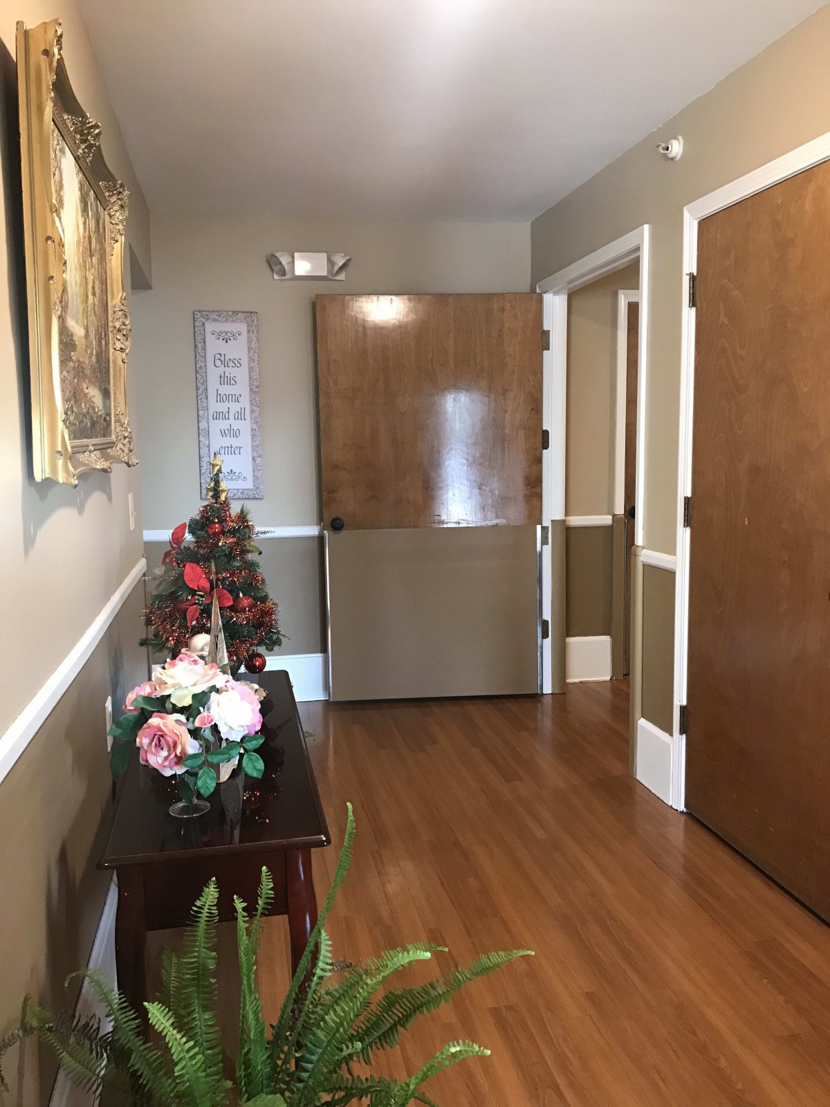 A hallway with decorative flowers and a wooden floor.