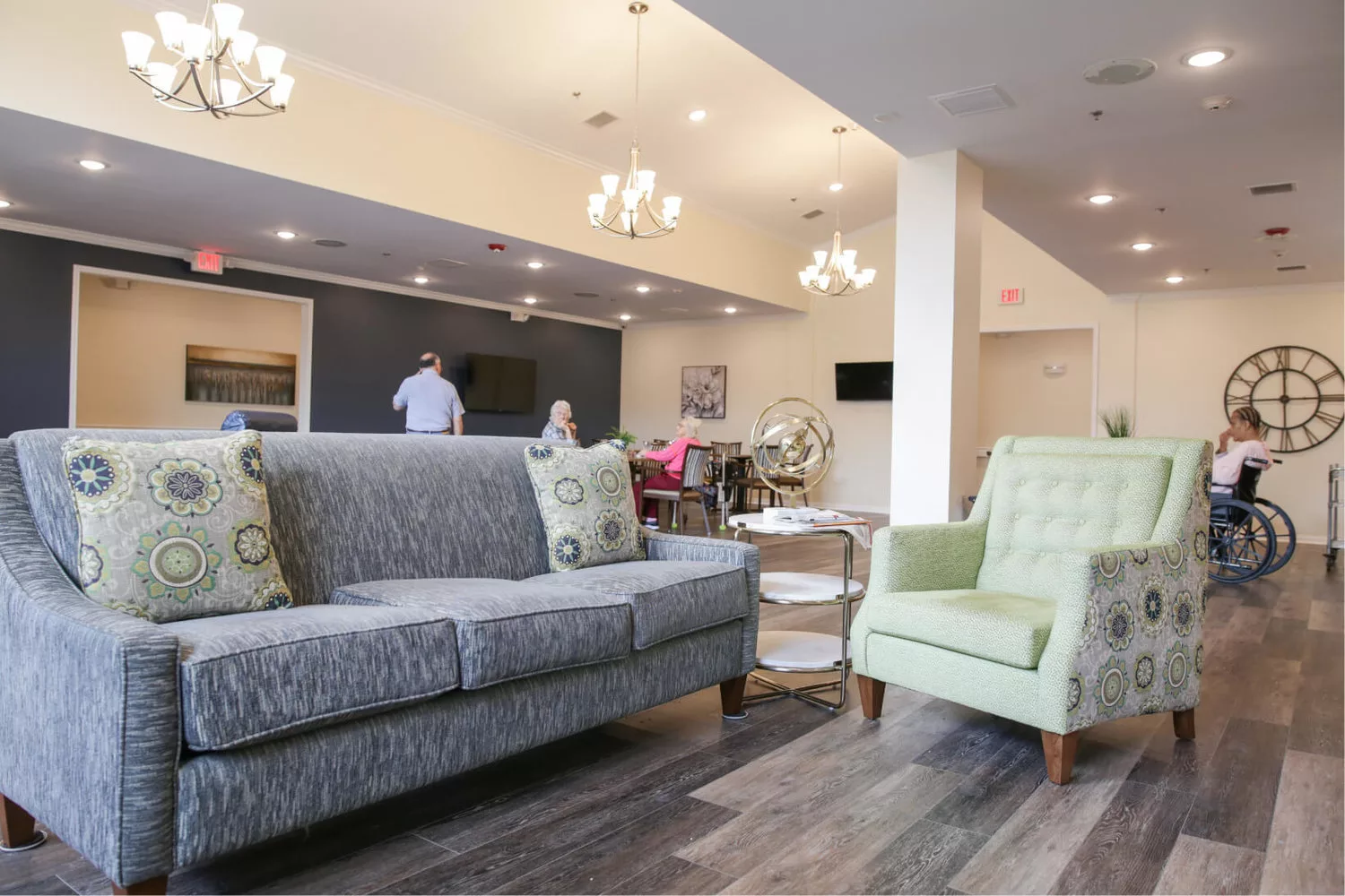 A modern living room with a comfortable sofa and armchair, featuring elegant lighting and stylish decor.