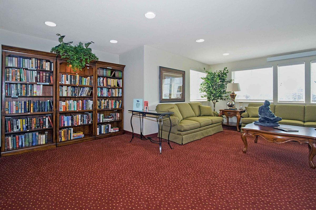 A cozy living room with a well-stocked bookshelf and comfortable seating.