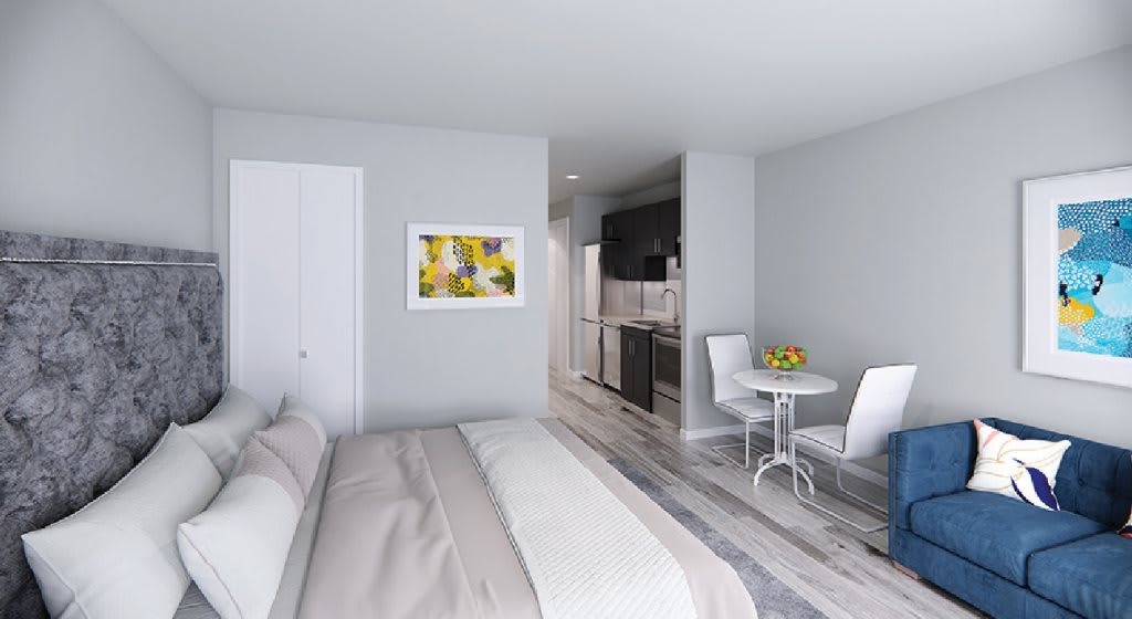 A modern, minimalist apartment featuring a cozy bedroom with a small kitchenette and dining area.