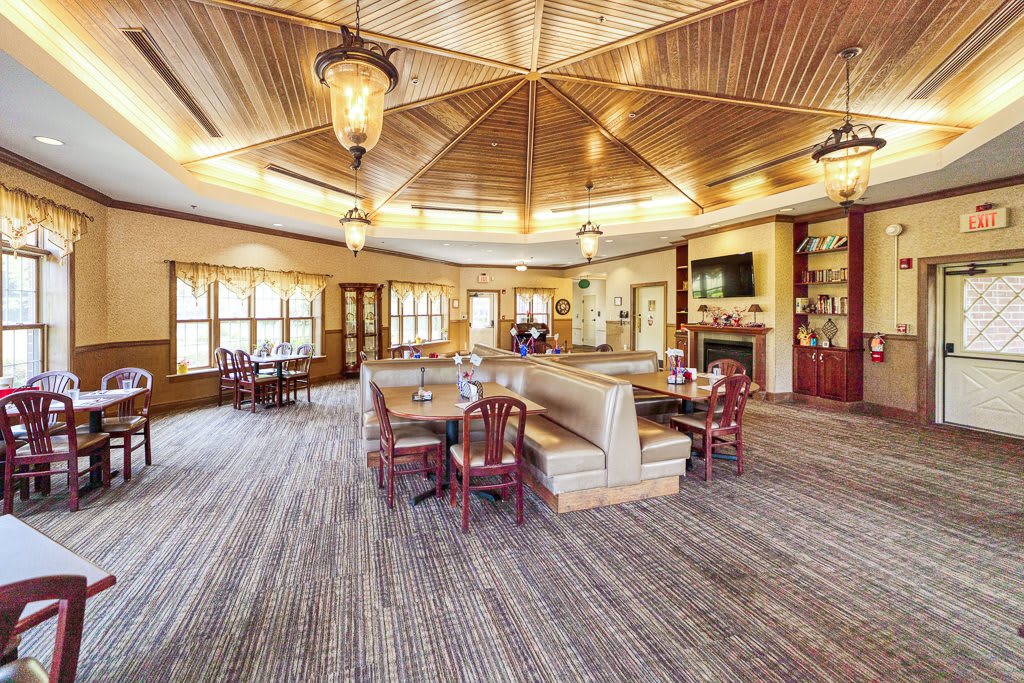 A cozy restaurant interior with a wooden ceiling and arranged dining tables.