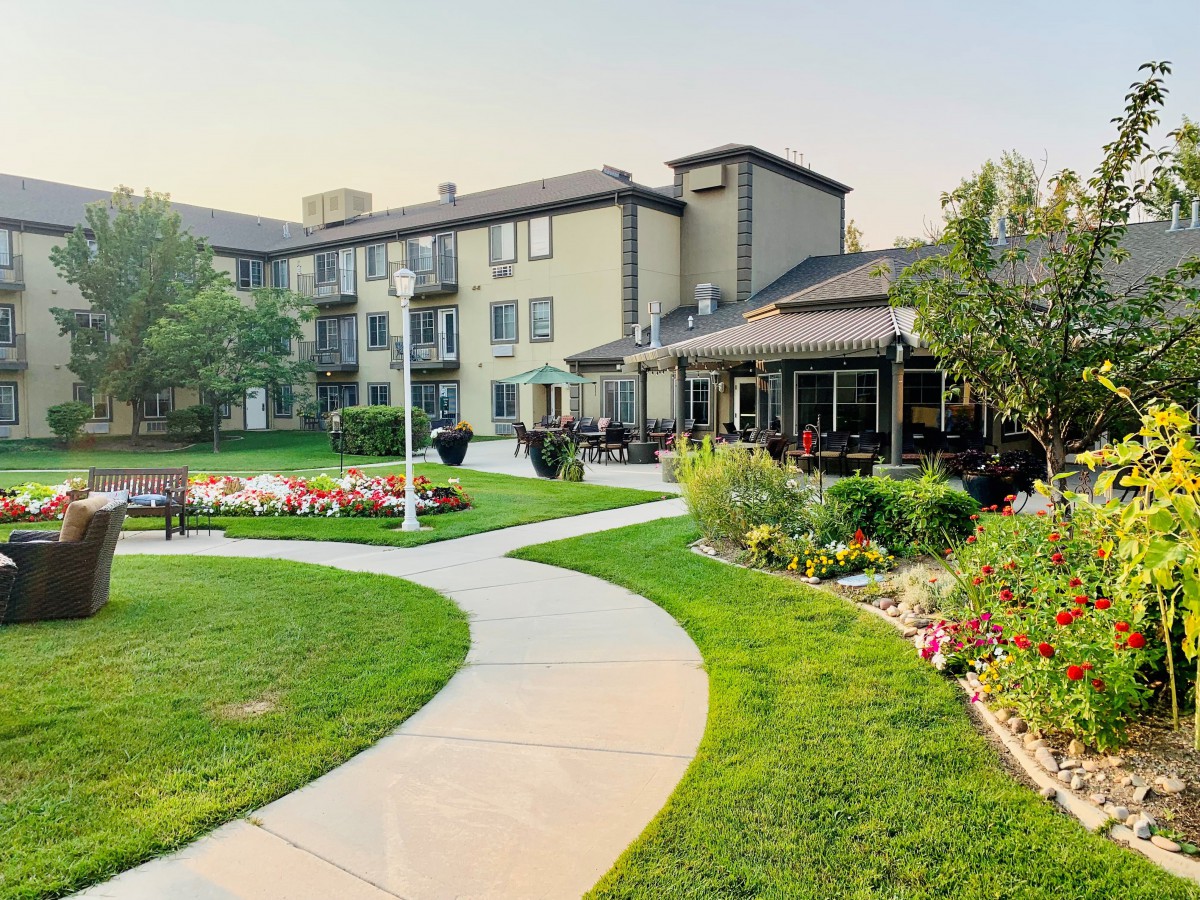 A scenic view of a residential building with a well-manicured lawn and winding pathway.