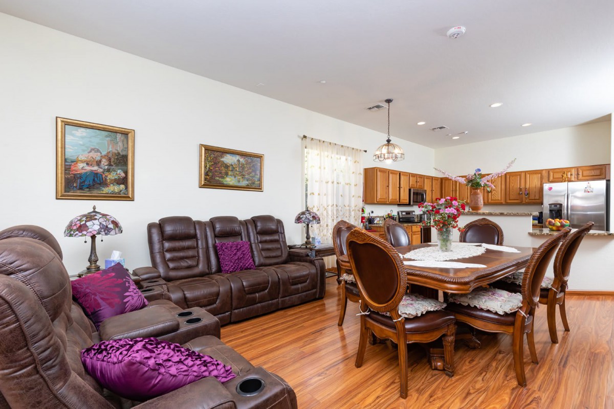 A spacious open-concept living and dining area with wood flooring and comfortable furnishings.