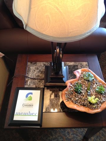 A cozy indoor setup featuring a lamp and a succulent plant arrangement on a side table.