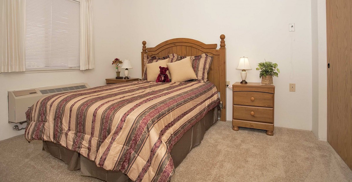 A cozy bedroom with a wooden bed and matching nightstands.