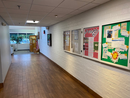 A well-lit school hallway featuring display cases with educational posters.