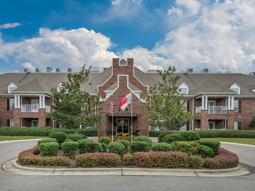 A beautifully landscaped residential building under a cloudy sky.