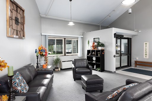 A modern and inviting lounge area featuring black leather furniture and decorative elements.