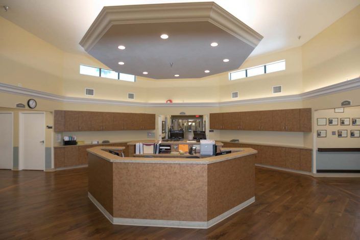 A modern reception area with a central desk and overhead lighting.