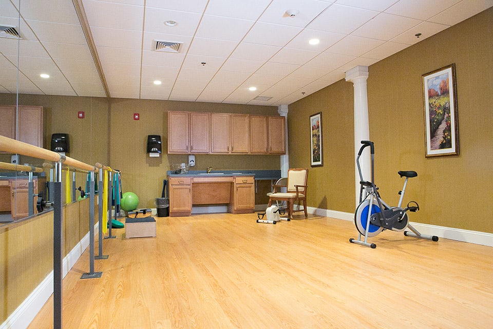 A well-equipped rehabilitation and fitness room with exercise equipment, including a stationary bike.
