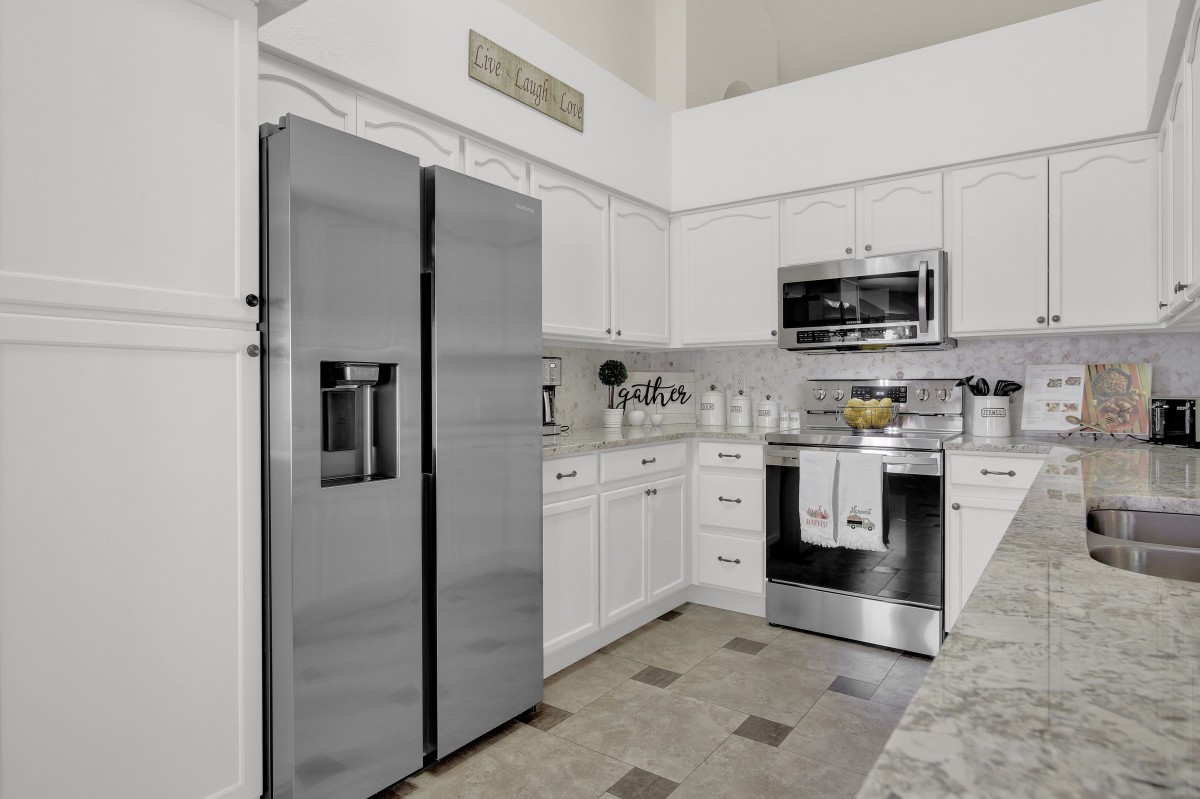 Modern kitchen with stainless steel appliances and white cabinetry.