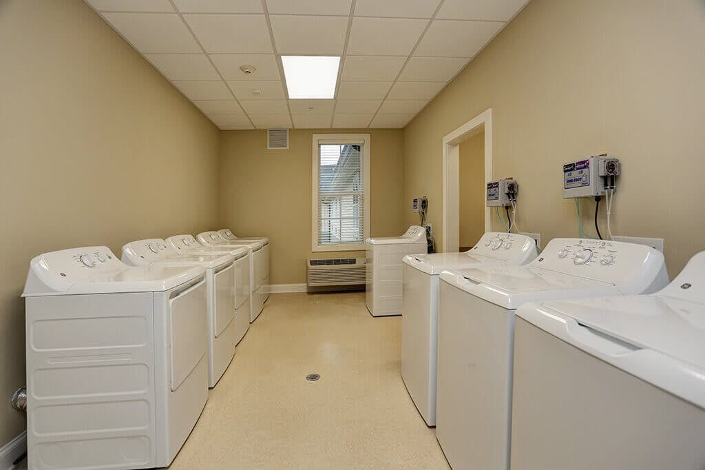 A clean and organized laundry room with multiple washing machines.