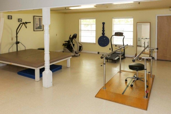 A gym interior featuring various exercise equipment and workout areas.