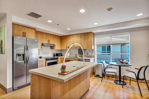 A stylish modern kitchen featuring wooden cabinets and a spacious island, perfect for cooking and dining.
