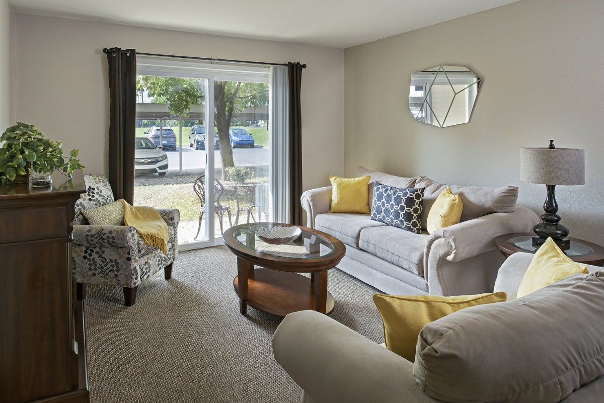 A cozy living room with stylish furnishings and a large window view.