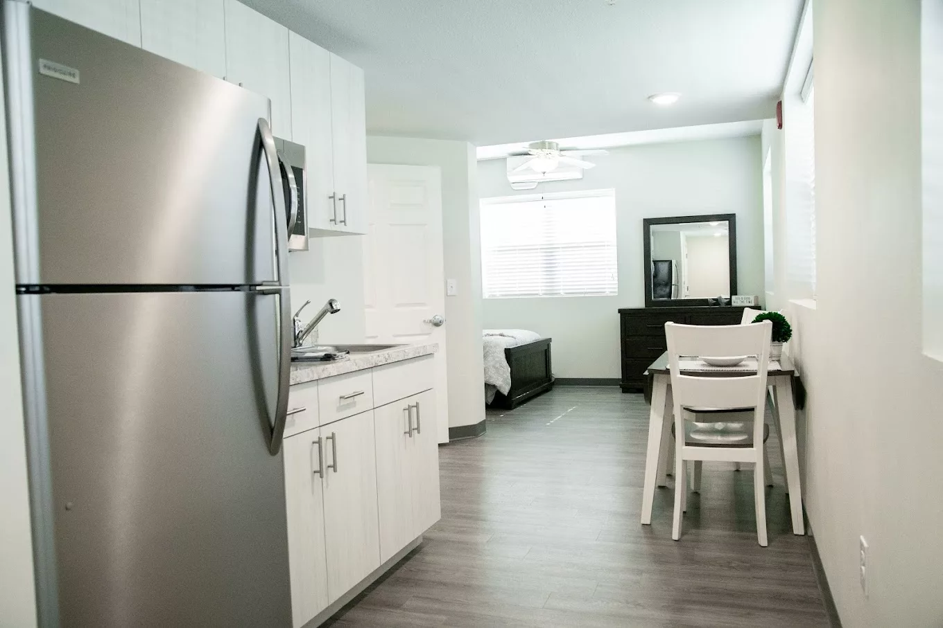 A modern, minimalist kitchen interior in an apartment setting.