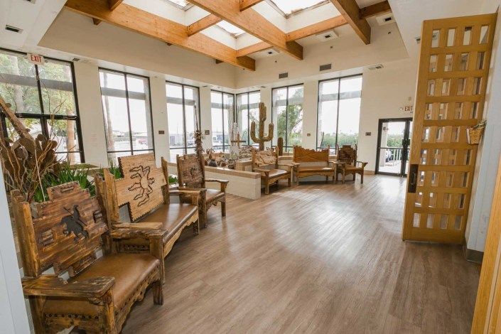 Spacious lobby with natural lighting and wooden furnishings.