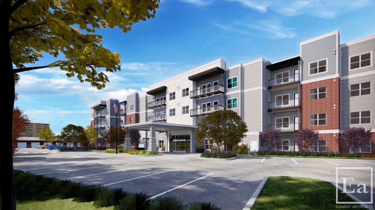 A modern residential apartment building with a parking lot and landscaped surroundings under a partly cloudy sky.